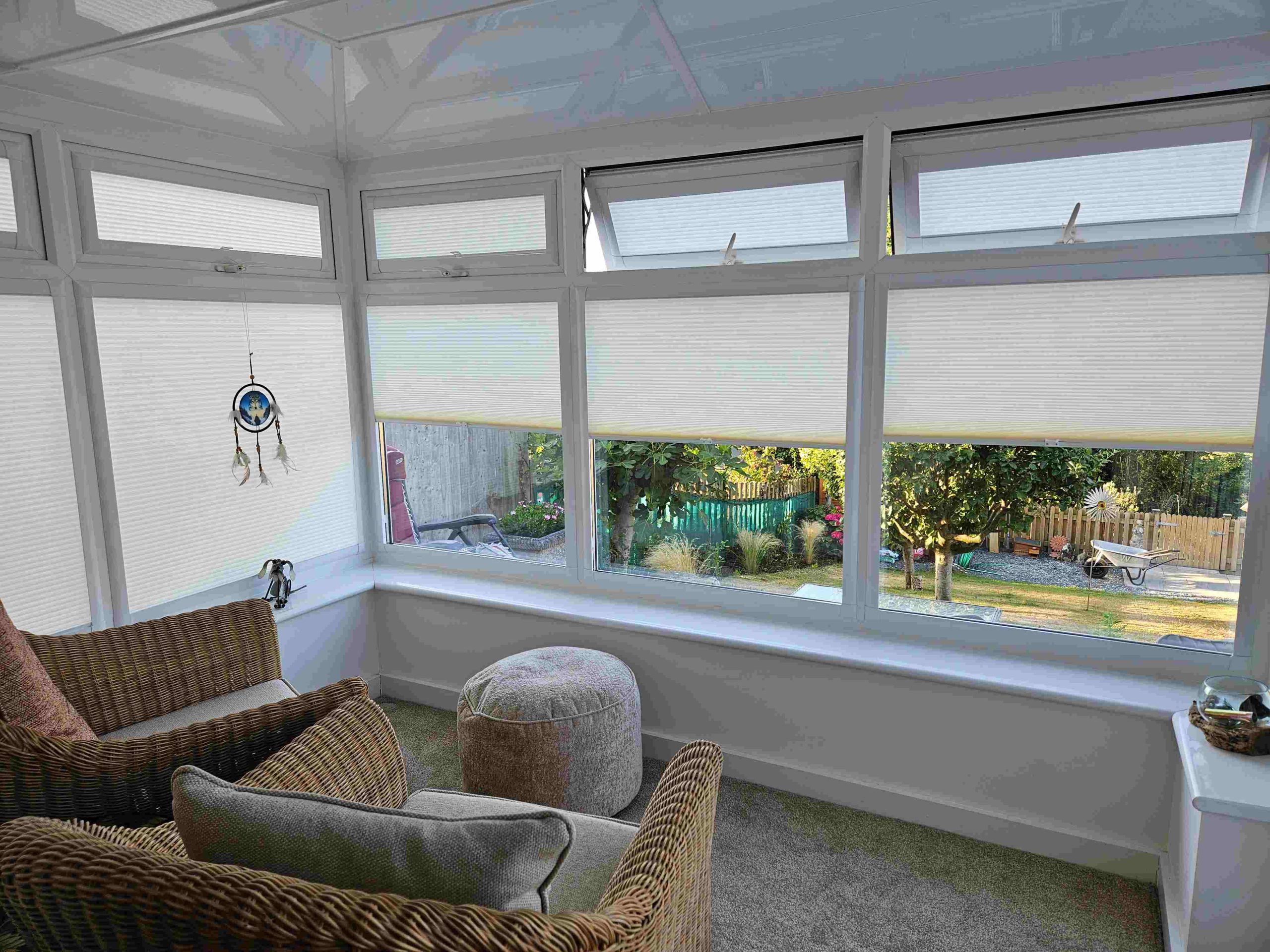 Conservatory pleated blinds lowered while upper opening windows remain open